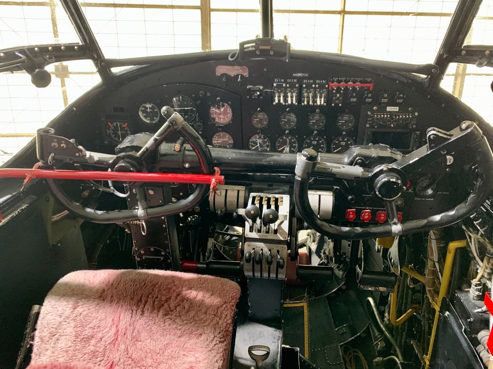 The instrument panel and control columns of a vintage Avro Lancaster airplane.