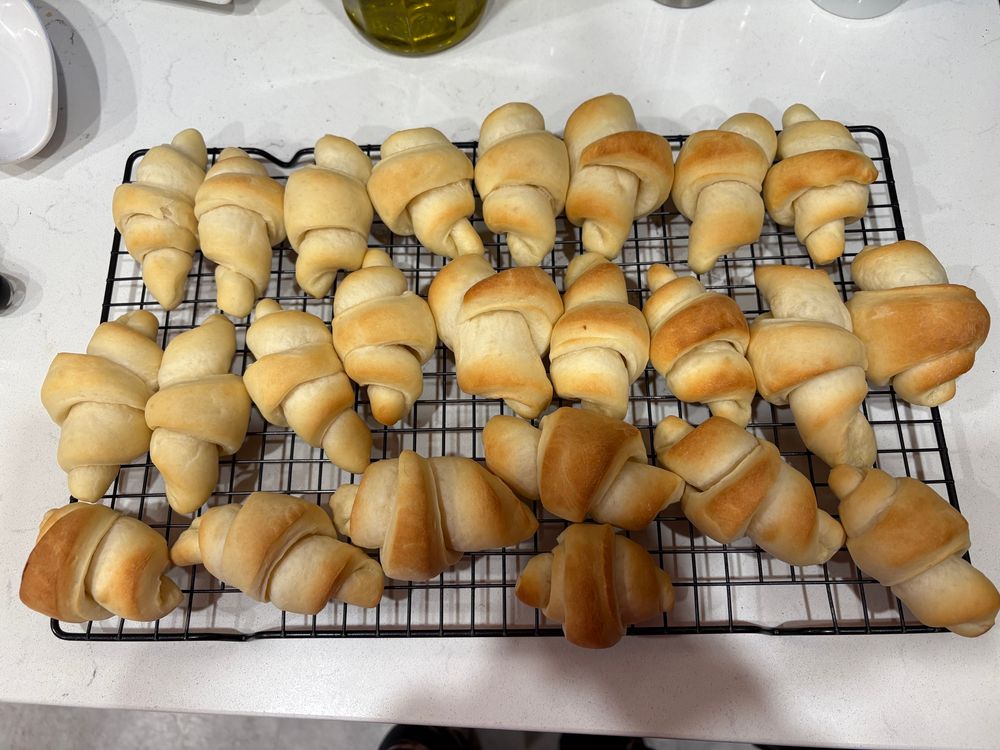 A wire cooking rack filled with 2 dozen crescent rolls