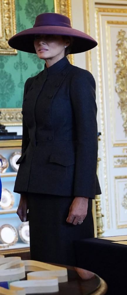 Melanie Trump mit Hut und schwarzem Kostüm im Buckingham Palast