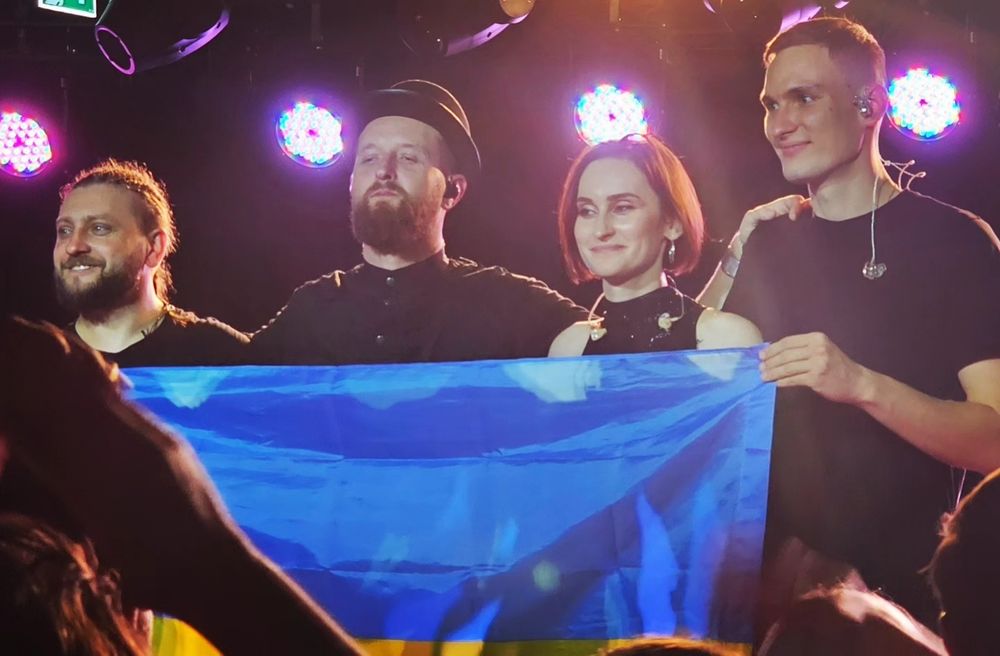 Ukrainian Band Go_A at the end of their concert in Manchester. The four musicians in the photo (from left to right : Ivan, Taras, Kate, and Ihor) hold the flag of Ukraine towards the audience.