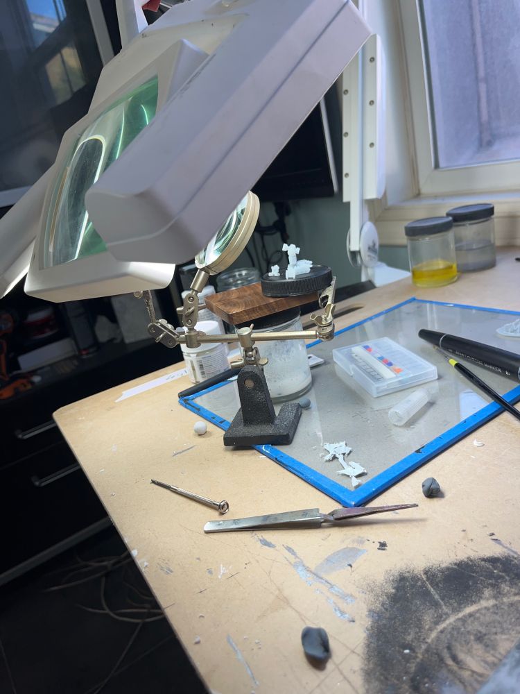 Photograph of a desk setup where there are two sets of magnifying glasses observing some 3d printed Perceptors 