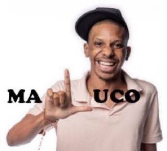 Lucas Penteado ex-bbb sorrindo fazendo um "L" com a mão completando a palavra "maluco" 