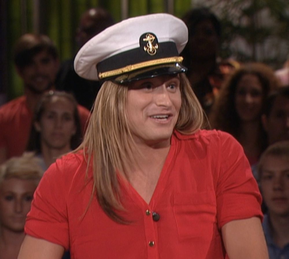 bb14 wil wearing a captain’s hat and red shirt in front of a live studio audience
