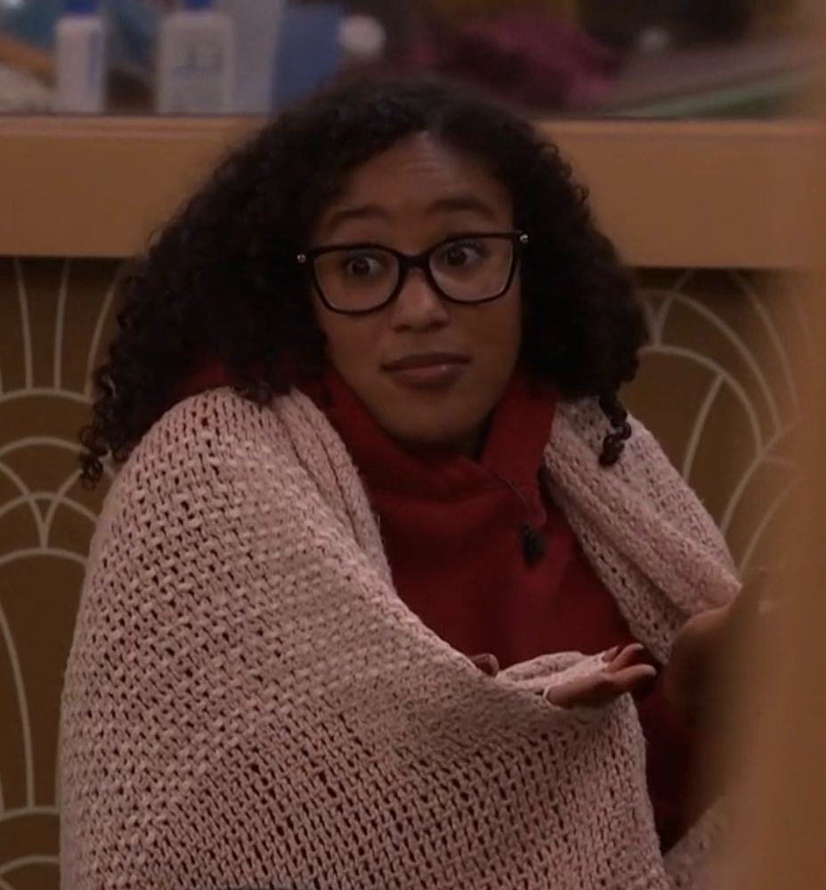 ashley shrugging with a blanket over her shoulders in the train room