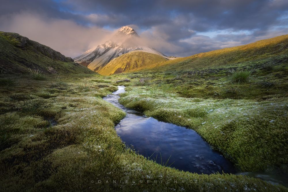 A photo from a beautiful morning in the southern part of the Icelandic highlands. Mossy meanders in the foreground and snowy mountain peaks in the background after a night's snowfall. It's a beautiful wild landscape full of contrasts.