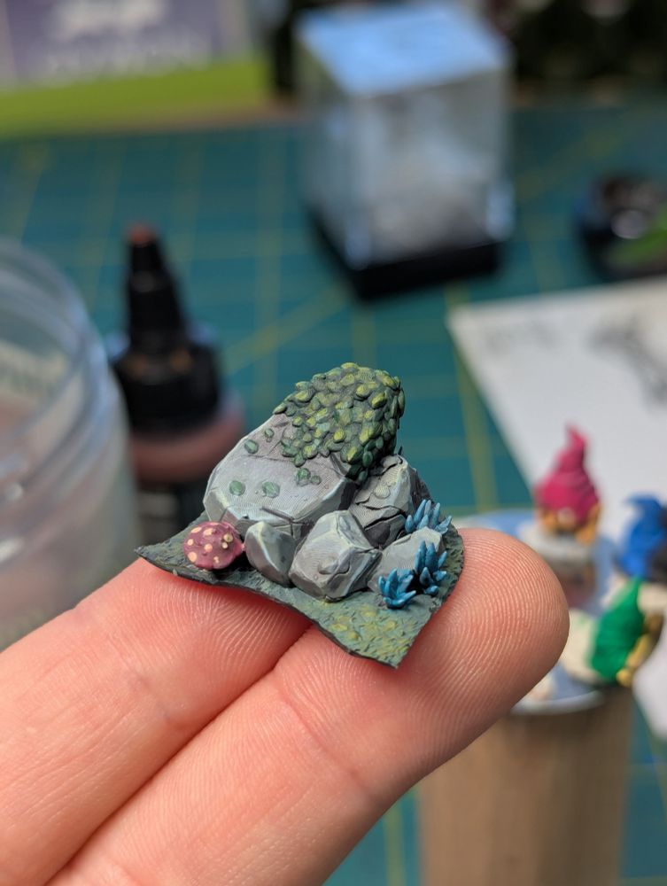 A picture of miniature rocks with leaves and mushrooms painted by hand 