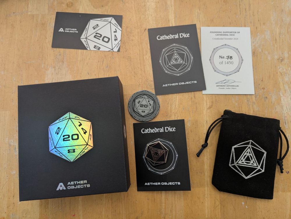 All the stuff they sent me: a box with the actual dice, certificate of authenticity, dice bag, custom coin, enamel pin… quite the haul, really. 