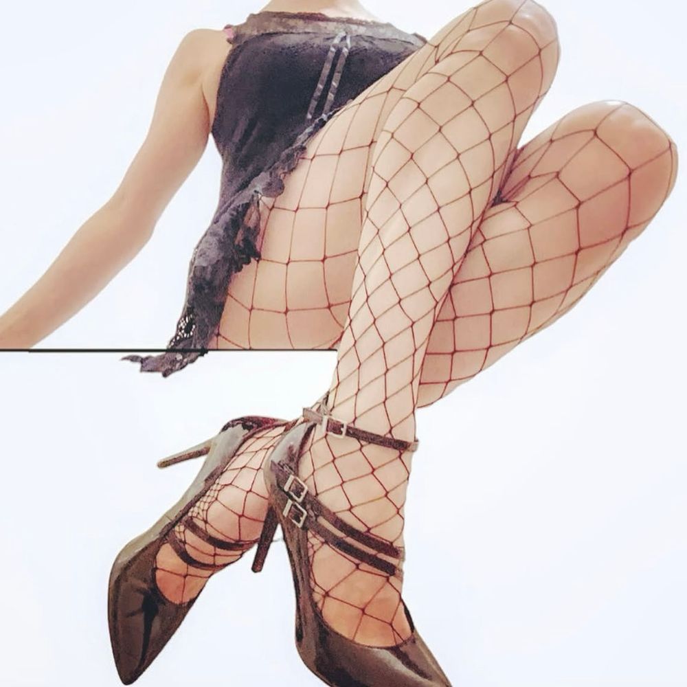 a photo of julia, she’s wearing fishnets, black heels and a black lace babydoll