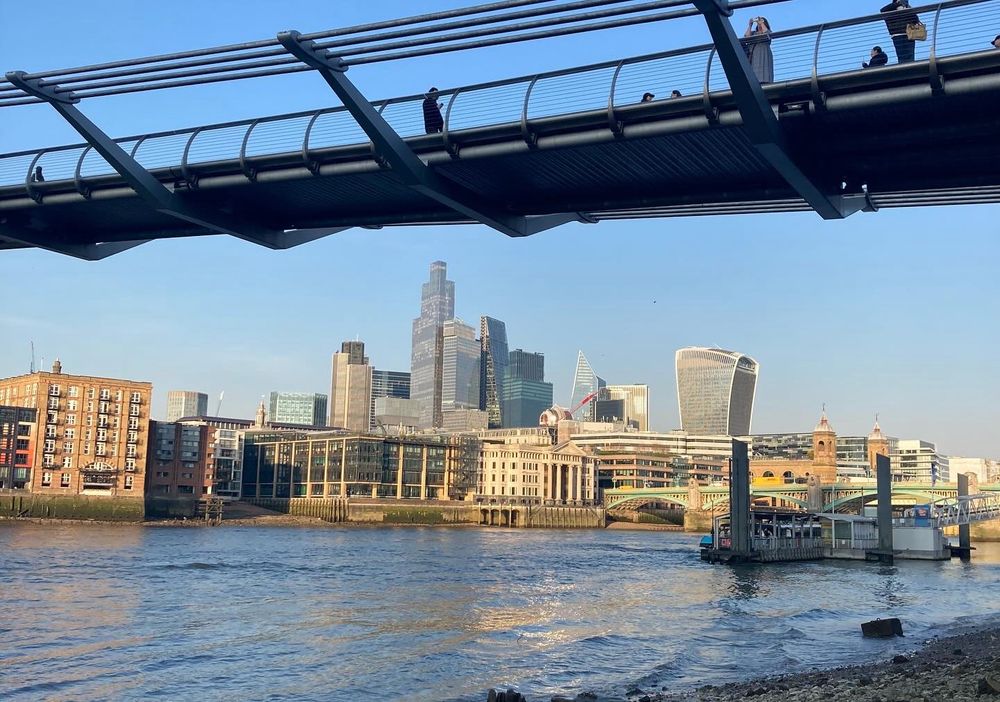 The City of London skyline viewed from the beach beneath the Millennium Bridge.