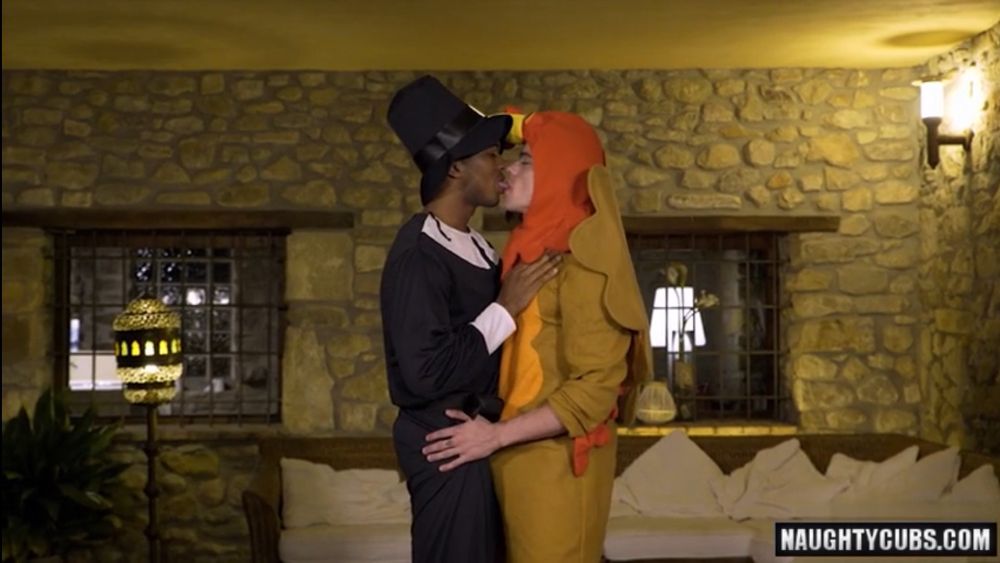 Gay porn still of a man in a pilgrim costume kissing a twink in a turkey costume 