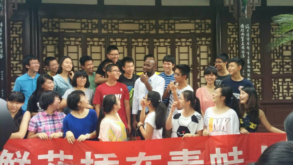 Nate surrounded by students with a banner in Mandarin