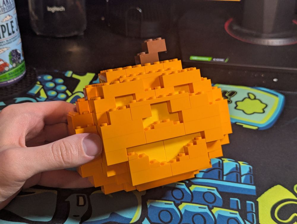 A Pear sized Jack O Lantern made of basic lego bricks.