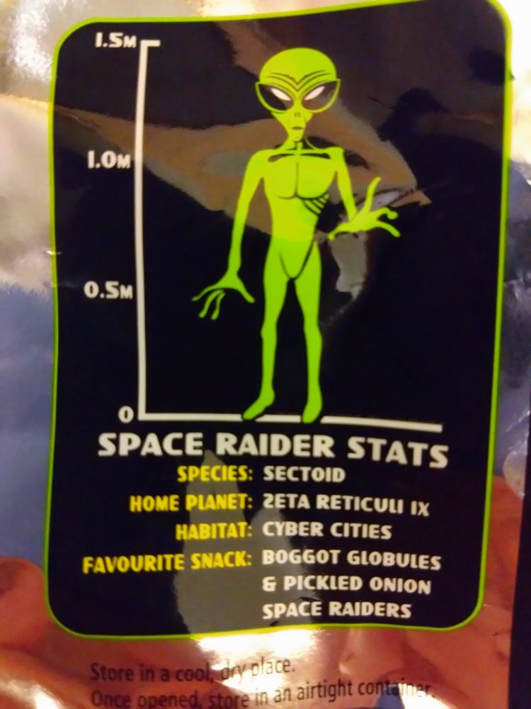 A picture of the back of a packet of Space Raider crisps, depicting the titular alien and their stats