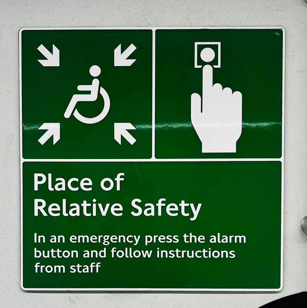 Green sign in London Underground that says “Place of Relative Safety”
