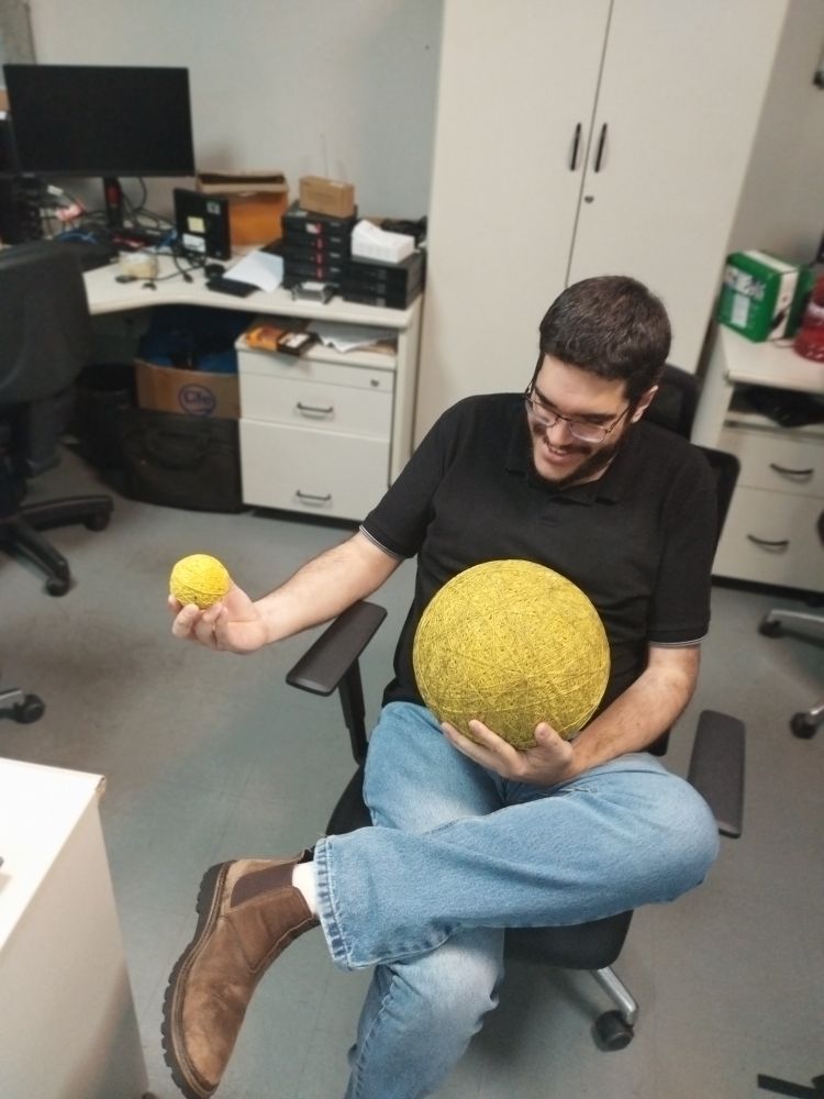 Eu de novo com a mesma roupa da anterior agora segurando uma bola de elástico do tamanho de uma bola de basquete no colo e na outra mão uma bolinha do tamanho de uma bola de tênis de elástico.

Wilso e Wilsim