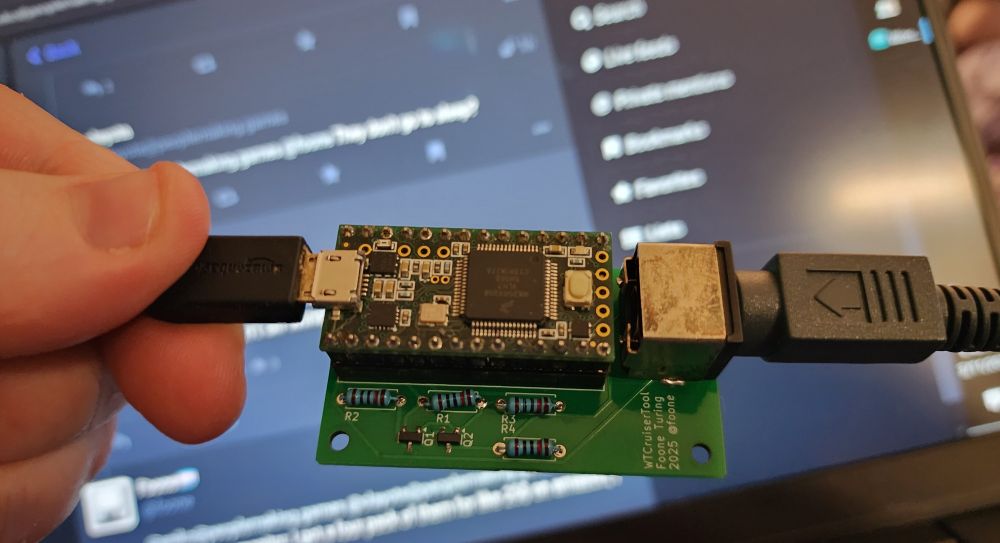 The WonderTools Cruiser Adapter device: A small PCB with a few resistors, mosfets, an attached Teensy microcontroller, and a PS/2 keyboard port. 