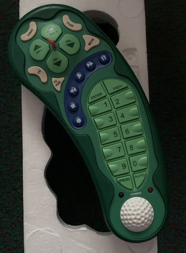 a tv remote shaped like a golf course, and colored similarly, with the green, rough, and sandpits colored buttons 