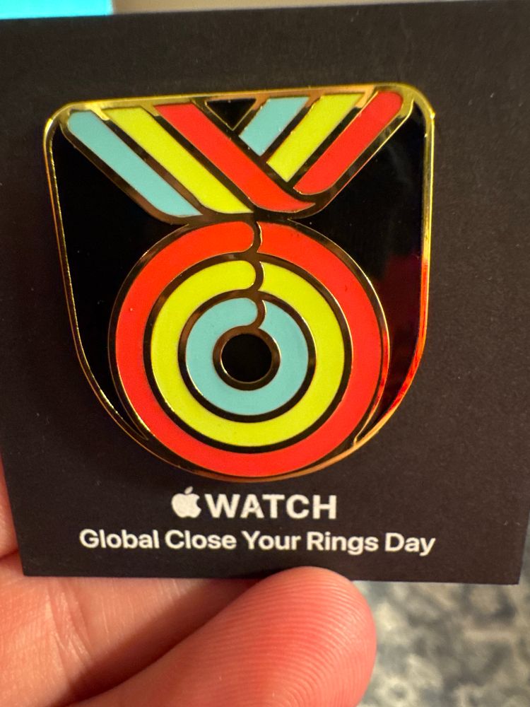 A picture of the Apple 2025 “Global close your rings day” pin. A medal with three different rings on it for fitness goals.  