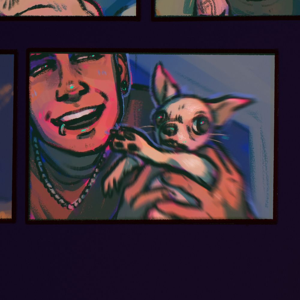 A crop of Felix. He has warm brown skin and a lip ring & ear stretcher. He is wearing a silver necklace and burgundy t-shirt. He grins as he thrusts his cream chihuahua at the camera.