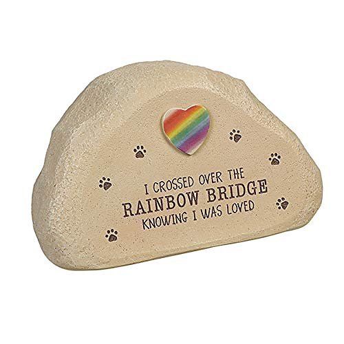 A tan rock with a rainbow heart at the top and tiny paw prints around the edges. The words read: I crossed the rainbow bridge knowing I was loved