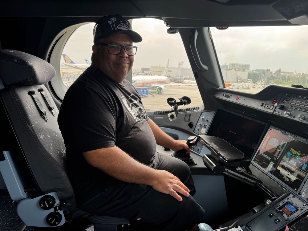 A pudgy 54-year-old black man with glasses sitting in the flight deck of a Delta Air Lines Airbus A-350 aircraft 