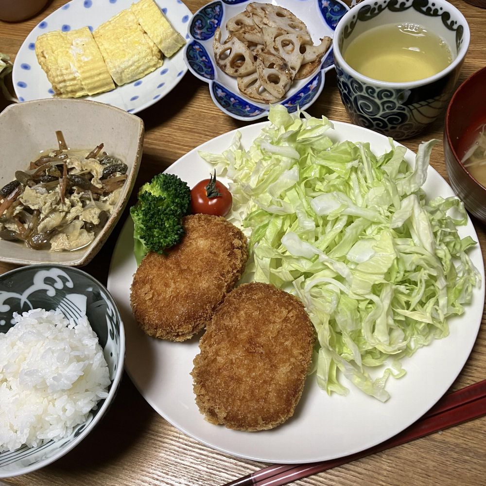 コロッケと千切りキャベツ、ブロッコリー、ミニトマトの盛り合わせに、ご飯、卵焼き、れんこんのきんぴら、つくしの卵とじ、煎茶、味噌汁が並ぶ和風の家庭料理の食卓
