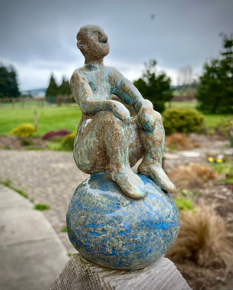 Fencepost Topper: Human figure seated on globe