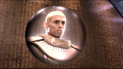 A spherical communication device showing the goa'uld system lord apophis looking angrily. It is floating in front of a golden wall full of hieroglyphs.