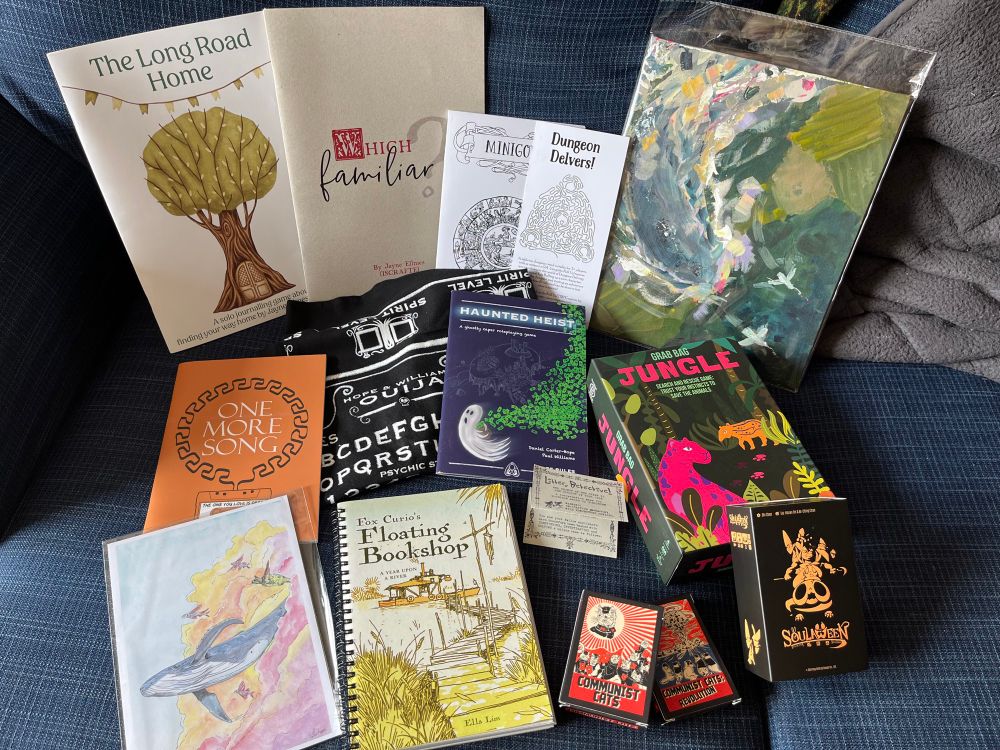 An art print of a flying whale and a more impressionist painting of a sky whale chasing birds alongside a selection of RPGs, two board games and one card game:
The Long Road Home
Which Familiar?
MINIGODS
Dungeon Delvers!
Litter Detective!
HAUNTED HEIST
Fox Curio's Floating Bookshop
GRAB BAG JUNGLE
Soulaween
COMMUNIST CATS