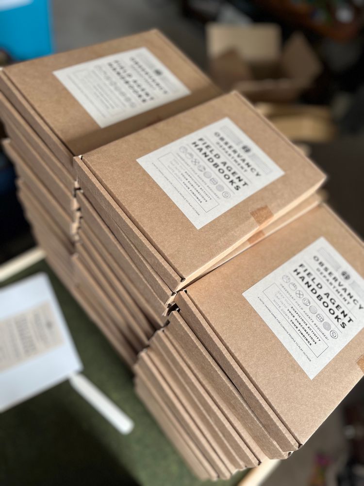 Sixty stacked brown boxes worth Field Agent Handbook labels
