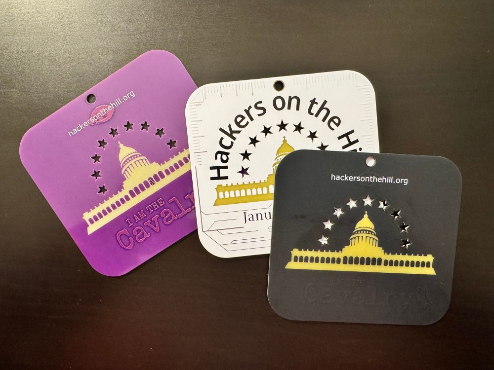 Three Hackers on the Hill badges, whites black, and purple