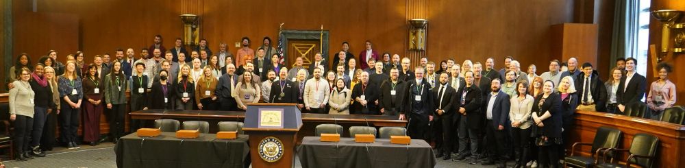 Around one hundred cybersecurity researchers and practitioners, and cyber policymakers in the Dirksen Senate Building room 106 for Hackers on the Hill 