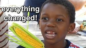 Photo of Tariq, the young boy known from the "It's Corn" song by the Gregory Brothers and Recess Therapy. A young African-American boy holding a bright yellow ear of corn as he sings about it.  You can find the video on Youtube or the song itself on Spotify.