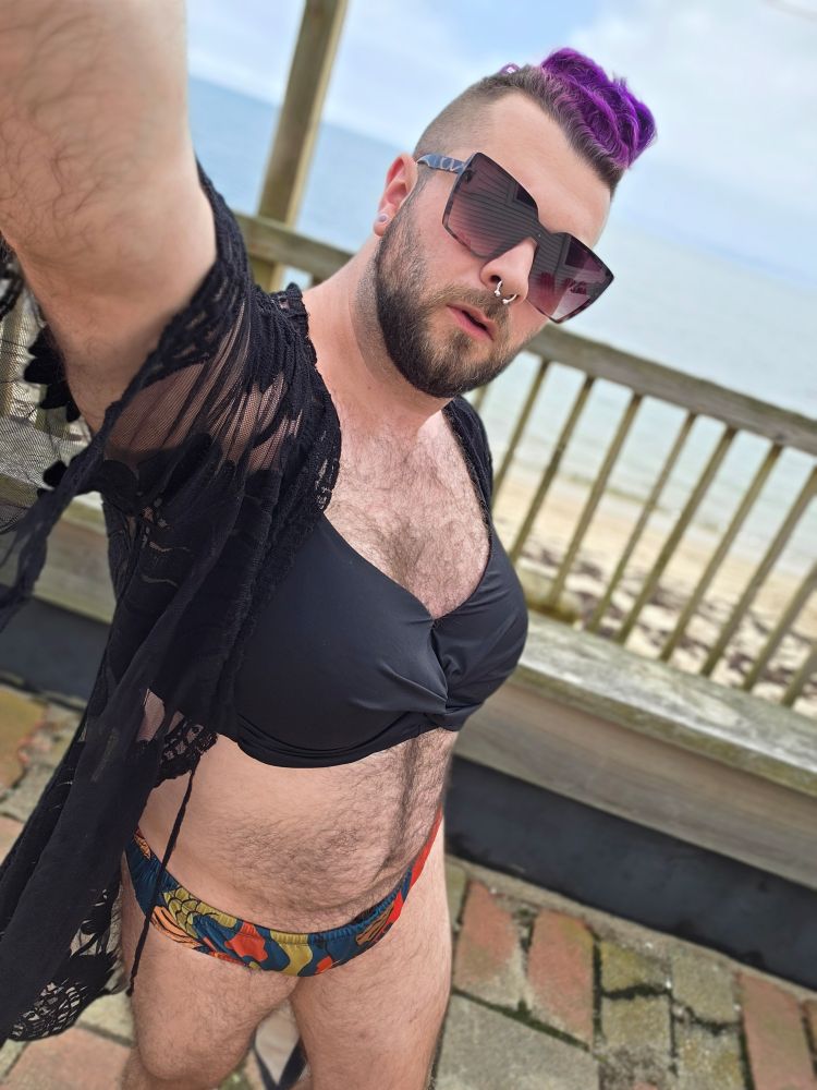 A selfie in a bikini and beach robe, with the beach in the background 