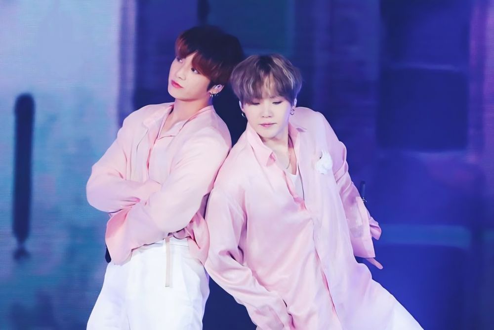 Yoonkook in light pink outfits performing the choreo to Boy With Luv.