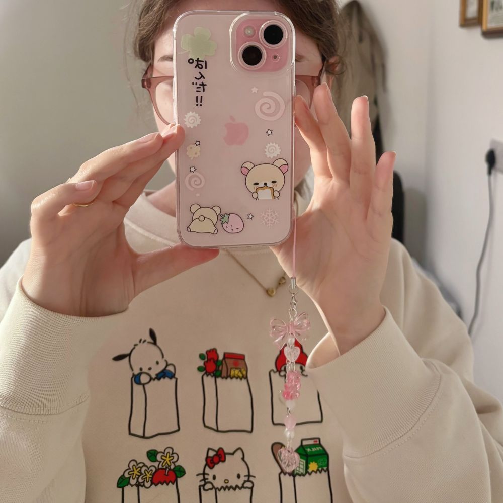 mirror selfie of op holding a pink iphone with a rilakkuma phone case and pink phone charm attached 