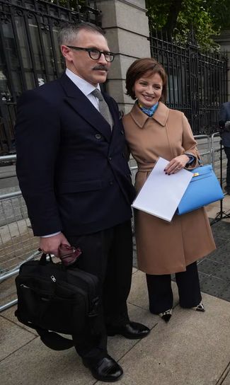 Maria Steen and husband, outside Oireachtas, on her failure to be nominated for the Irish presidential election. Sharp shoes, and her husband reminds me of someone