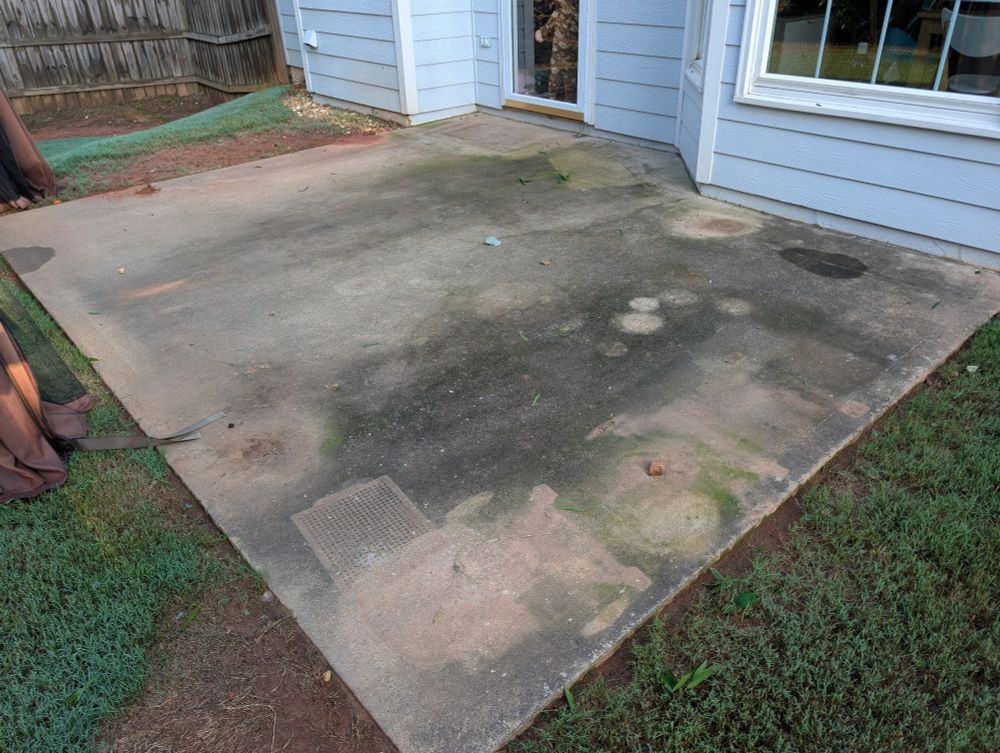 A dirty patio covered in questionable dark stains. 