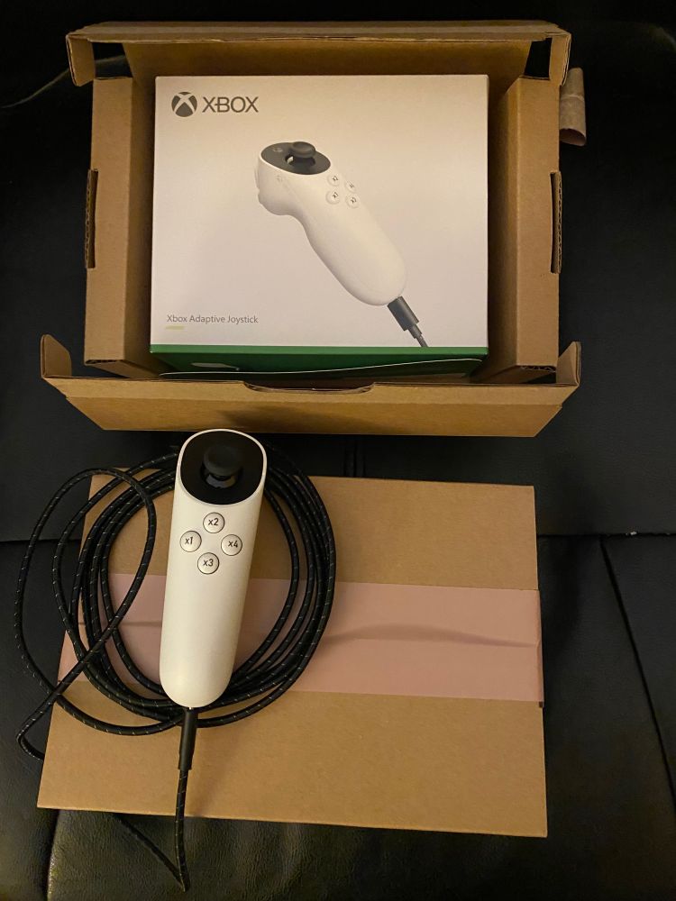 Two Xbox adaptive joystick controllers. One unboxed and the other still unopened.