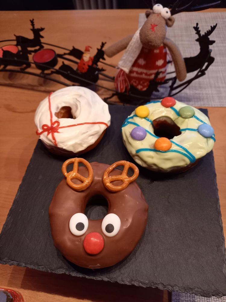 Donuts decorated like a present, a string of light and a red-nosed reindeer