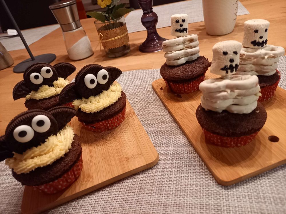Cupcakes with bats made of Oreos and skeletons made of Marshmallows and white chocolate coated mini pretzels.