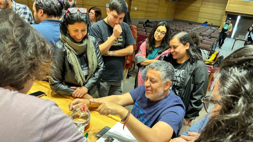 Patricio Castro, one of the OAE's Chilean NAECs, demonstrating the bottle globe to model the celestial sphere for a group of teachers standing around him
