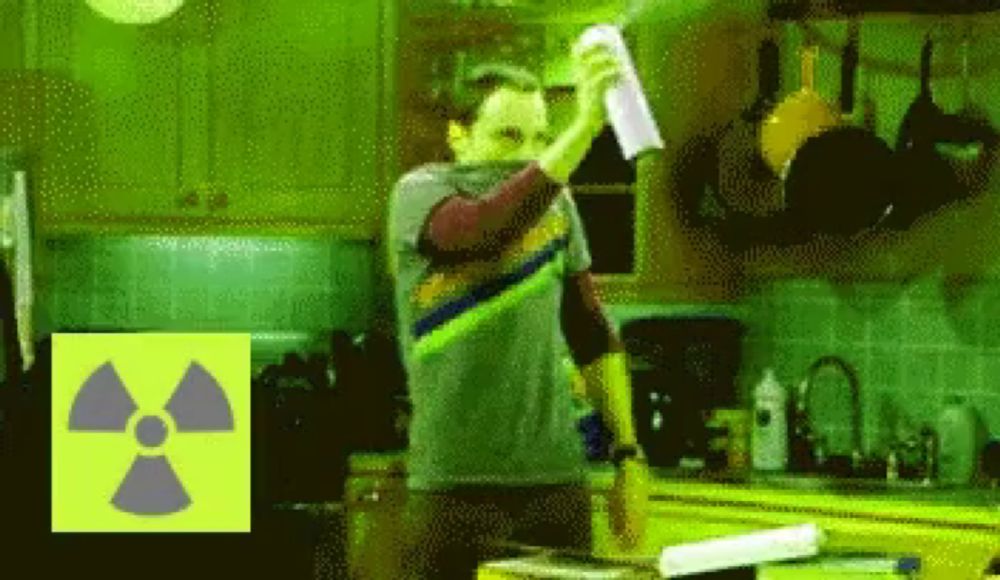 a man is standing in a kitchen with a nuclear symbol in the corner