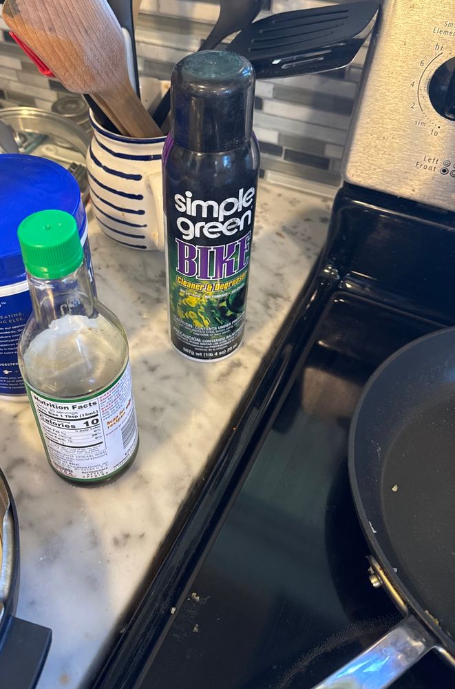 A kitchen counter with lots of stuff on it including Simple Green Bike Degreaser for some reason?!? 