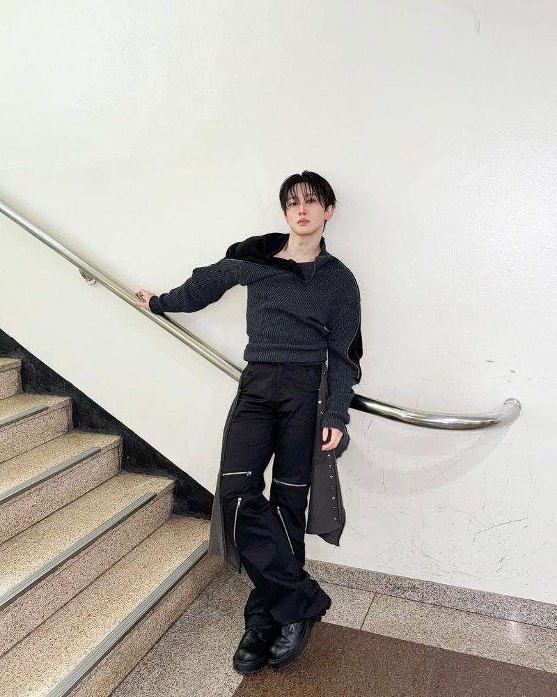 andteam fuma standing by the music bank staircase while leaning on the railing