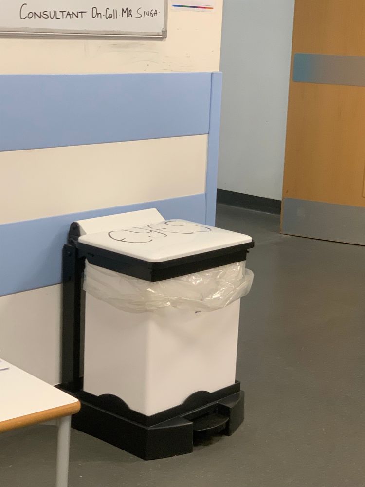 White bin with the word “eyes” written on the lid in black ink 
