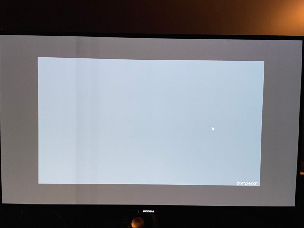 a close up photo of an OLED gaming monitor with a grey rectangle in the middle. The monitor shows signs of defect as there is a large discoloration line through it.