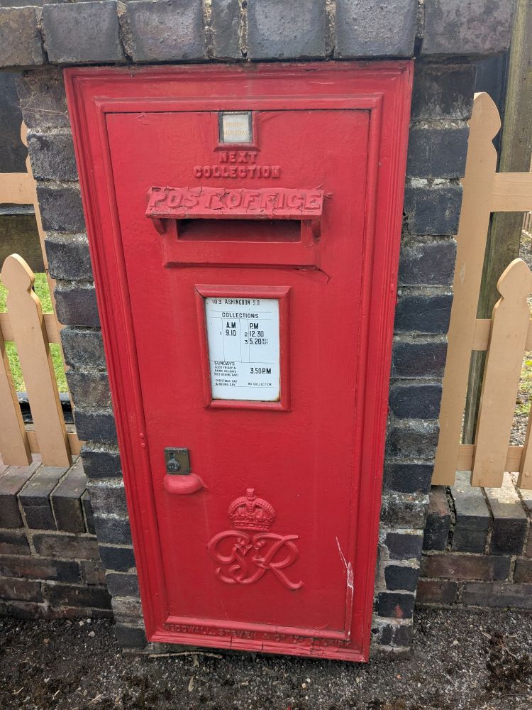 A rectangular red postbox on the top written next collection with times in a white square, also a different crown underneath with the letters g iv R