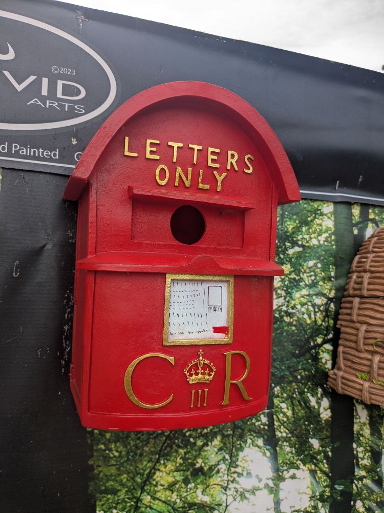 A bird box shaped like a small postbox, red with a round top with the words Letters only in gold. The letters C III R in Gold at the bottom 