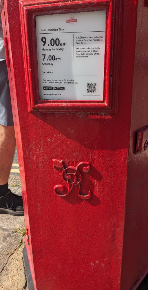 A red hexagonal postbox with clear lines and VR entwined in the middle